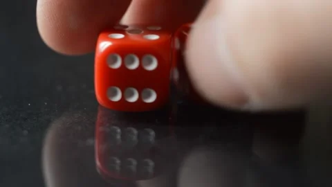 Player's hand put two red game dice on a glass table. Video stock 229640711