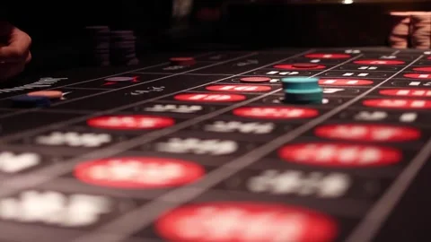 Players placing bets on roulette game table at a casino Stock Footage 255680947