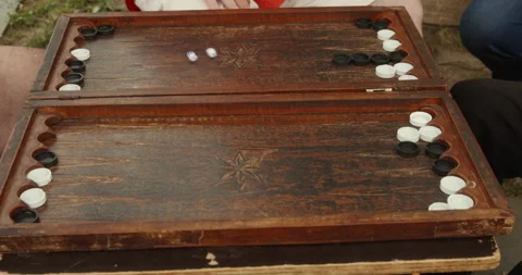 Players playing backgammon board game in backyard during summer Stock Footage 252169019