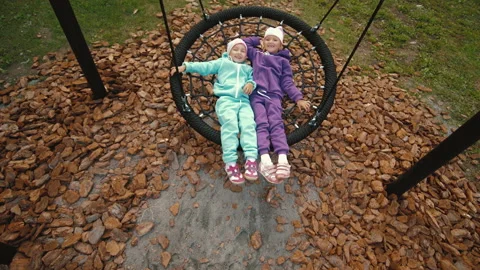 Playful active kid swinging on round rope swing on playground, having fun Stock Footage 138044209