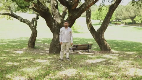 Playful bearded man dabbing in the park Stock Footage 323363463