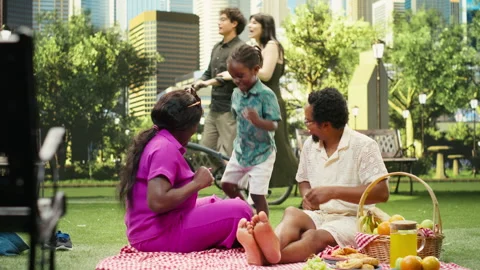 Playful boy doing funny dance moves with parents during picnic with blanket Stock Footage 341407033