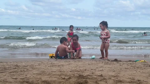 Playful Children Having Fun on Sandy Beach with Breaking Ocean Waves Stock Footage 346007362