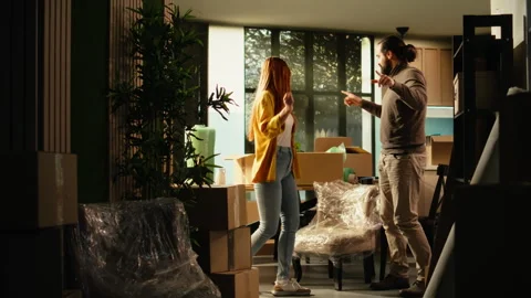 Playful couple doing silly dance in new house after moving day Stock Footage 342902056