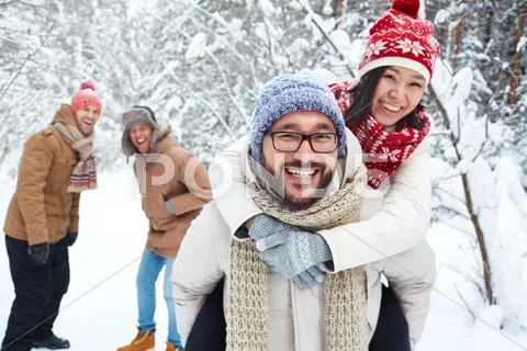 Playful couple having fun in winter forest Stock Photos