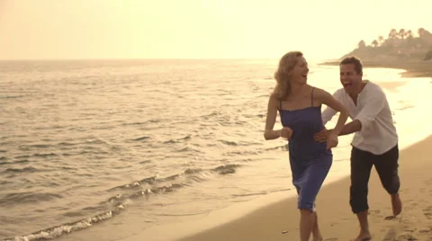 Playful couple running and chasing on beach. Stock Footage 43654334