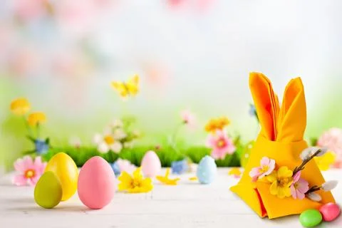 Playful Easter composition featuring a bunny-shaped gift bag, pastel eggs, .. Stock Photos