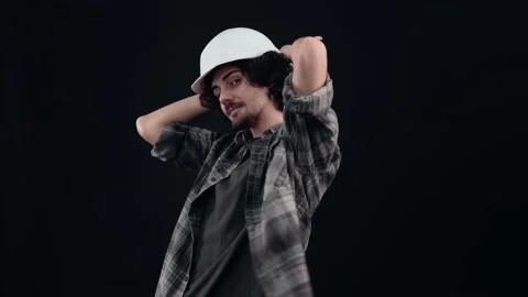 The playful engineer, with a white helmet, optimistically puts his palms on his Video stock 155632535