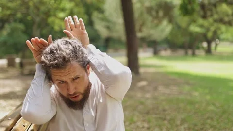 Playful man making deer antlers gesture in the park Vídeos de archivo 323301461