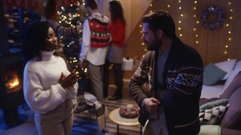 Playful nice bearded man making a surprise for best friend, passing a present to Stock Footage 121593243