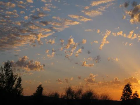 Playful rays in the clouds at sunset Stock Photos