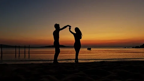 Playful Romantic Couple Dancing at Sunset Beach Silhouette 库存影片 335522509