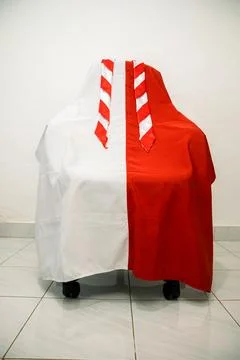 A playful setup with chair draped in split red and white fabric, evoking my.. Stock Photos