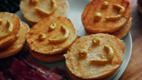 Playful smiley faces drawn across bun halves, 4K Stock Footage 341117640