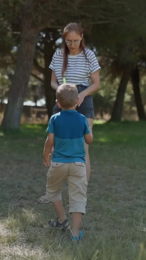 Playful son chasing mother in the park Stock Footage 327874405