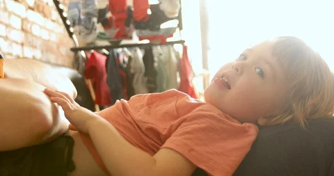 Playful toddler lying on sofa 스톡 동영상 112637827