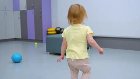 Playful Toddler Turning with Curious Expression in Modern Indoor Setting Видео 305004238