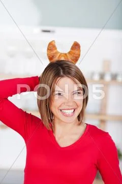 Playful woman with croissant horns Stock Photos