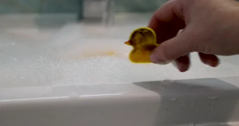 Playful yellow rubber ducks float in a cheerful bath with bubbles, evoking 動画素材 308936602