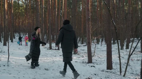 Playful young couple chasing each other and having fun in a winter forest. Video stock 311955541
