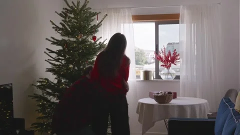 Playful young couple having fun near decorated Christmas tree in cozy room Stock Footage 324922951