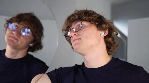 Playfully stubborn expression as man lifts his chin and pouts while holding a mi Stock Footage 312981792