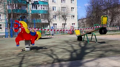 Playground is closed due to covid-19 pandemic.A warning tape is closed the swing Stock Footage 129727151