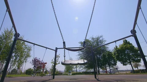 The playground is closed, the swing moves. In the background you can see cars 스톡 동영상 129524028