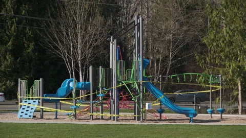Playground equipment surrounded by caution tape during safety inspection Stock Footage 312698430
