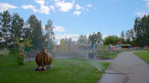 Playground in the forest and watering machine pours Stock-Footage 207951154