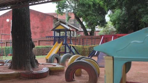 Playground scene with tree, slides, and tire obstacles Stock Footage 332384078