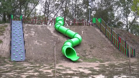 Playground slide tunnel with climbing wall in an empty park for children fun Stock Footage 333497396