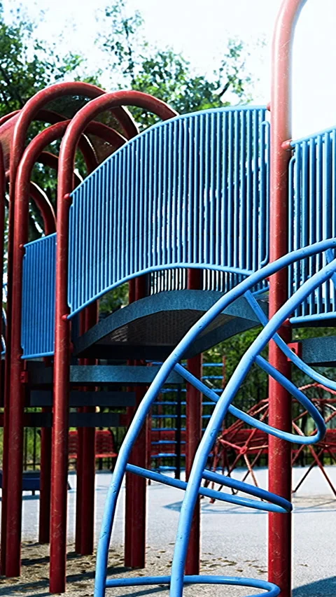 Playground structure with red and blue elements in a park setting Stock Footage 334193761