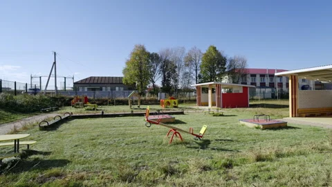 Playground structures stand on lush green grass field 動画素材 334152005