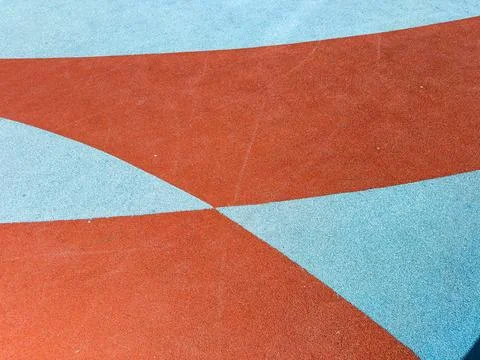 A playground surface with blue and red rubber patterns designed for children. Stock Photos