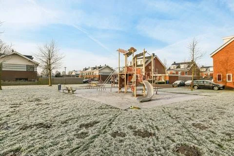 A playground in a yard with snow on the ground Stock Photos