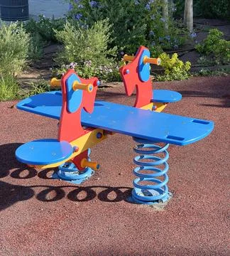 Playground in yard in summer with new spring swings for two children and safe Stock Photos