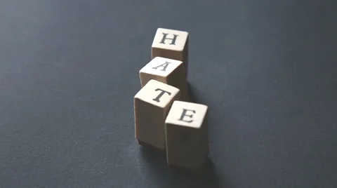 Playing and typing the word "hate" with alphabet stamps Stock-Footage 56450793