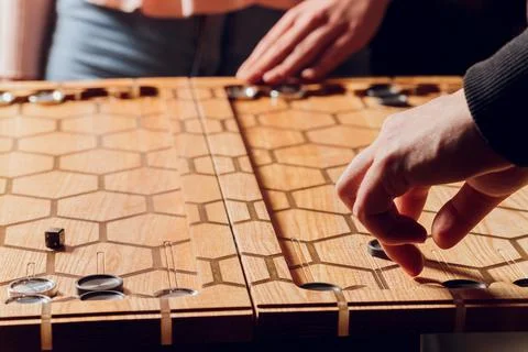 Playing backgammon game. Man play board game. Dice on wooden board. Stock Photos