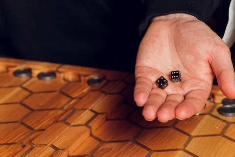Playing backgammon game. Man play board game. Dice on wooden board. Stock Photos