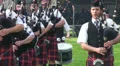 Playing bagpipe band entering Highland Gathering HD Footage