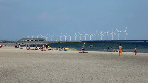 Playing ball on the beach in front of windmills at sea Video stock 40583392