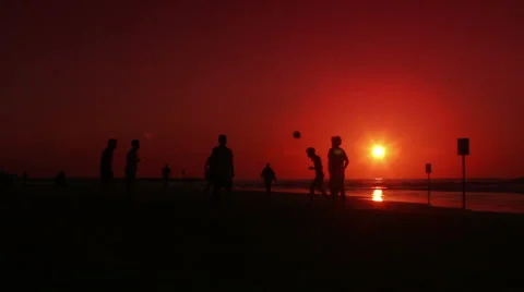 Playing ball on the sandy beach at the sunset. Video stock 45604343