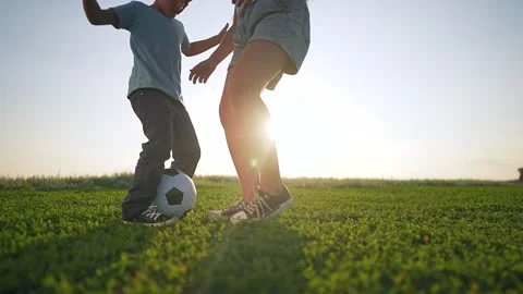 Playing ball under sunset sky. Children active in outdoor sport fun. Girl kicks Vídeos de archivo 316064482
