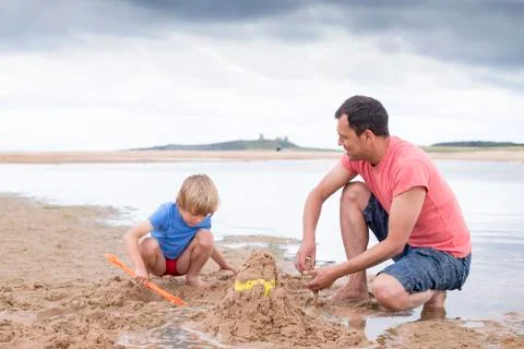 Playing on the beach with dad 库存照片