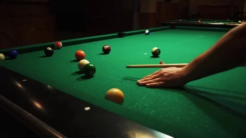 Playing billiards, blowing a cue on the ball, the ball hit the pocket, the ball Stock Footage 77142974
