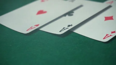 Playing cards with aces are arranged on a green felt surface, emphasizing their 動画素材 334150235