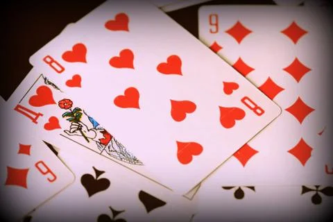 Playing cards scattered on the table close-up. Retro style toned, vignetting Stock Photos