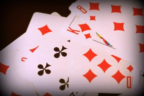 Playing cards scattered on the table close-up. Retro style toned, vignetting Stock Photos