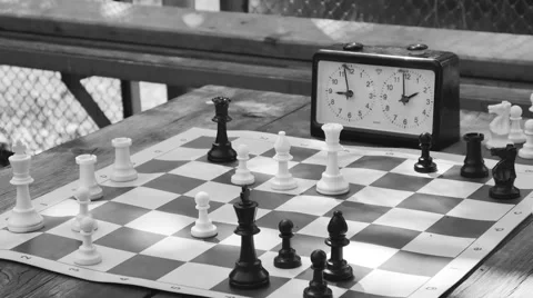 Playing chess with a clock at a table in the park, monochrome, retro Video stock 64806300